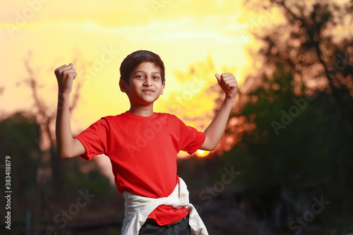 Happy and excited child doing winner gesture with arms raised