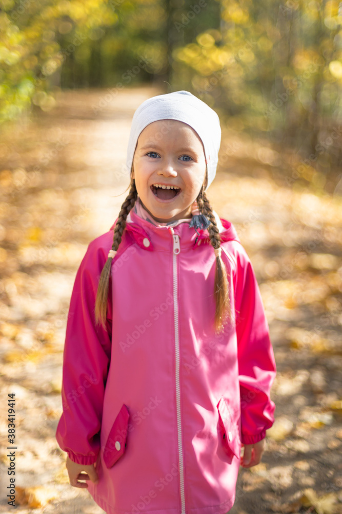 Moscow /Russia -10 04 2020: Happy little girl resting and walking in nature in the autumn forest near the lake in Moscow region of Russia with yellow and orange autumn leaves