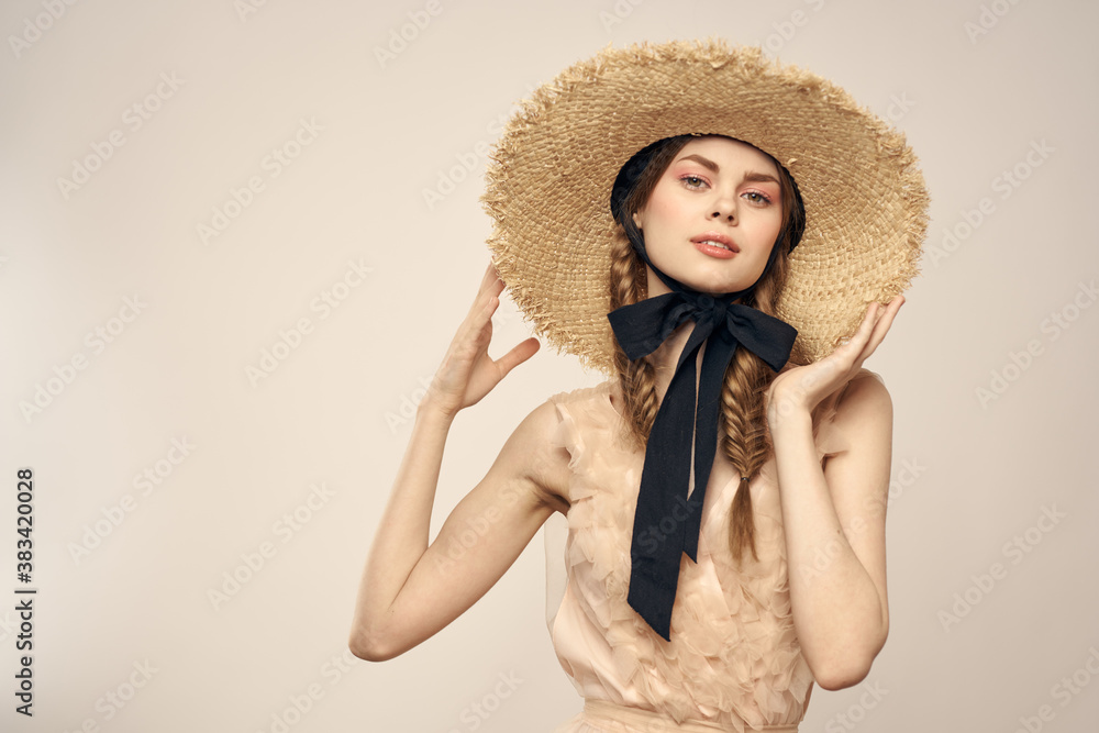 Romantic woman in a hat and dress on a light background gestures with her hands portrait fun emotions cropped view Romantic woman in a hat and dress on a light background gestures with her hands portrait fun emotions cropped view