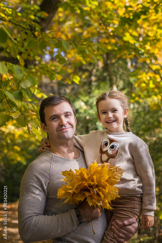 Moscow /Russia -10 04 2020: Happy family -father and daughter resting and walking in nature in the autumn forest near the lake in Moscow region of Russia with yellow and orange autumn leaves