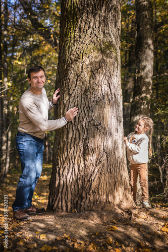 Obraz na płótnie Moscow /Russia -10 04 2020: Happy family -father and daughter resting and walking in nature in the autumn forest near the lake in Moscow region of Russia with yellow and orange autumn leaves w salonie