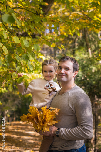 Obraz na płótnie Moscow /Russia -10 04 2020: Happy family -father and daughter resting and walking in nature in the autumn forest near the lake in Moscow region of Russia with yellow and orange autumn leaves w salonie