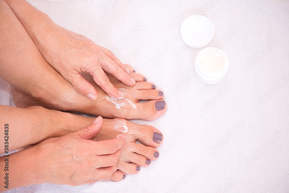 Woman applying body lotion on her feet