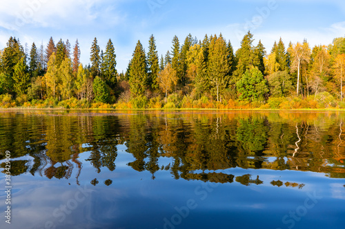 Panoramic view of the autumn forest with reflection on the calm water of the lake. Welcome to Russia!