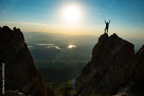the joy of success of the top climber and the views of the majestic mountains © emerald_media