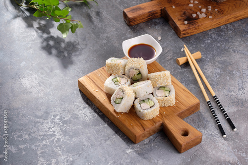 Roll made of Fresh cucumber and chicken and salad inside in a gray background. Delicious food. Beautiful still life with a portion of rolls on a wooden board.
