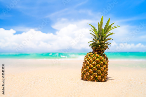 Pineapple on tropical beach background. Summer vacation and healthy food concept.