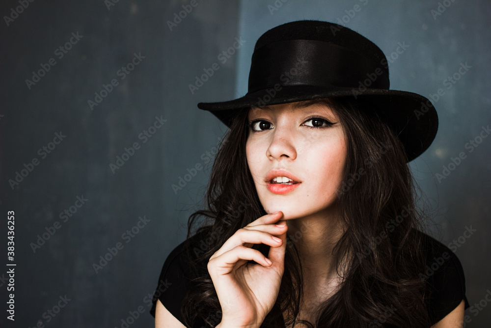 Portrait of beautiful brunette woman in hat, stylish girl posing on blue background Portrait of beautiful brunette woman in hat, stylish girl posing on blue background