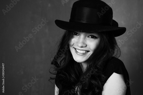 Portrait of beautiful brunette woman in hat, stylish girl posing on blue background © Zaliya