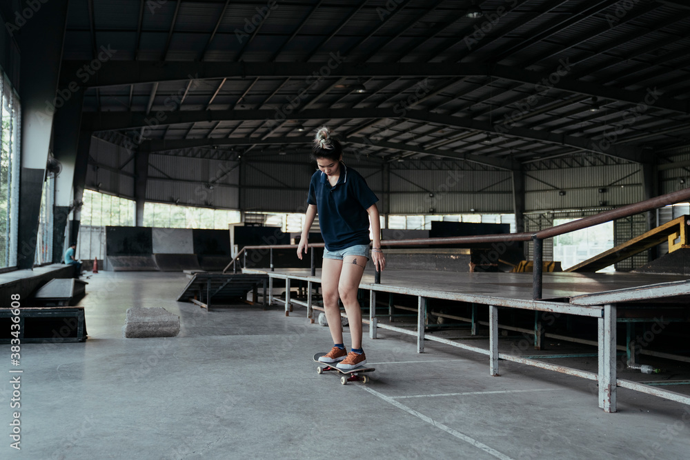 Obraz premium Skate board player woman playing board indoors.