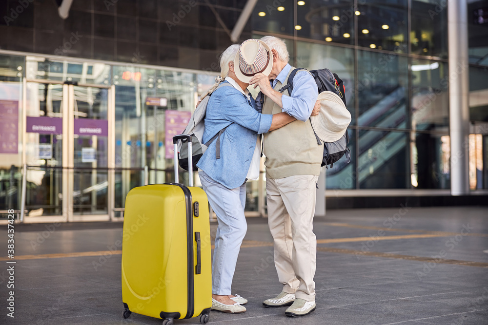 Senior couple hiding their faces behind a hat Senior couple hiding their faces behind a hat
