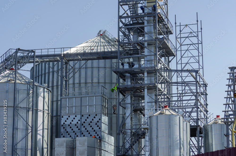 Construction of a modern grain terminal on a blue sky background. Construction of a modern grain terminal on a blue sky background.