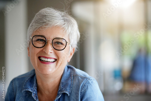 portrait of a beautiful smiling 55 year old woman with white hair photo