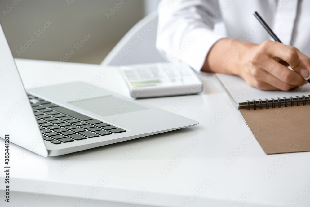 Laptop on table of young woman working in office, closeup Laptop on table of young woman working in office, closeup