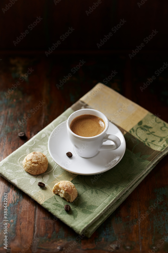 Obraz premium Cup of coffee with amaretti (Italian biscuits) on rustic wooden background. 
