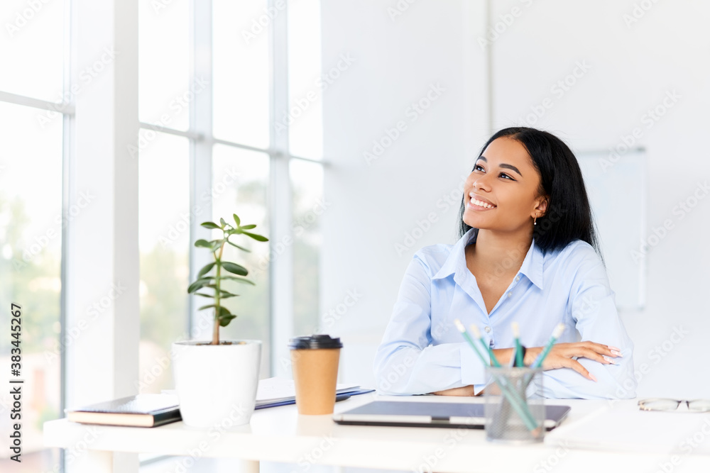 Smiling pretty businesswoman posing at her desk in a bright modern office looking to copy space. Smiling pretty businesswoman posing at her desk in a bright modern office looking to copy space.