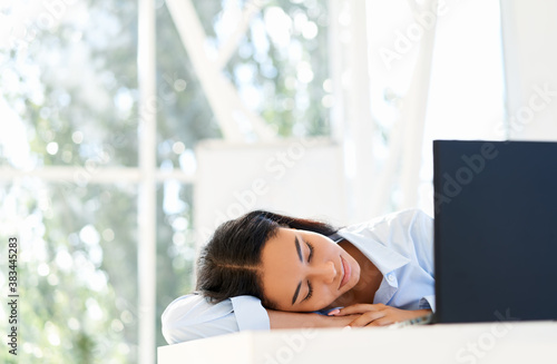 Tired businesswoman sleeping on the workplace on office desk