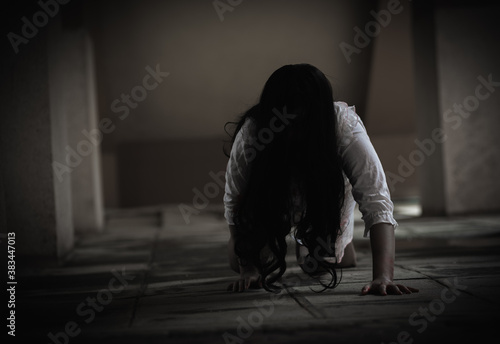 Female zombie in blood. Asian Woman ghost with blood. Horror scary fear in dark house creepy crawling move slowly creeping out. Hair covering face her eye looking camera, Halloween festival concept