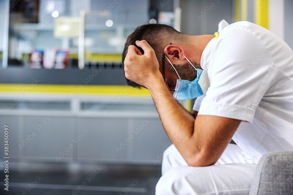 Young desperate doctor sitting in hall and getting anxious because his patient is very ill. Young desperate doctor sitting in hall and getting anxious because his patient is very ill.