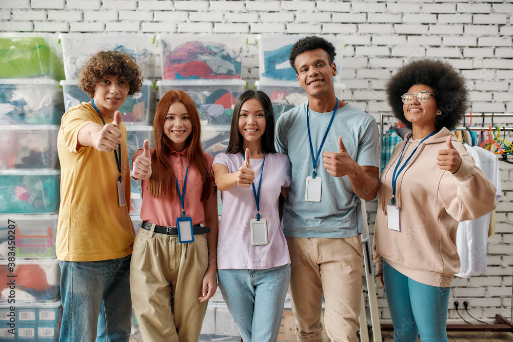 A group of diverse people smiling and donating books to a charity