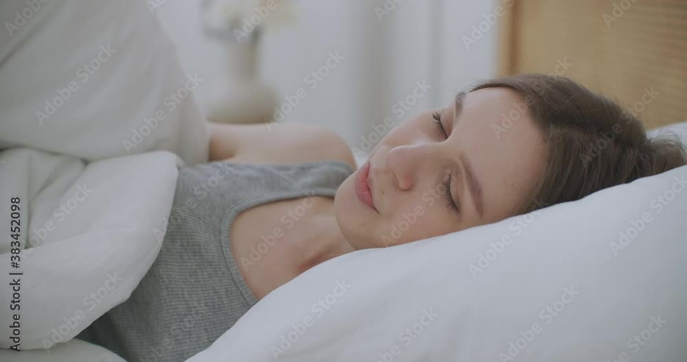 Woman wakes up raise stretches hands in bed feels healthy Woman wakes up raise stretches hands in bed feels healthy