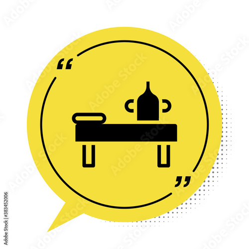 Black Massage table with oil icon isolated on white background. Yellow speech bubble symbol. Vector.
