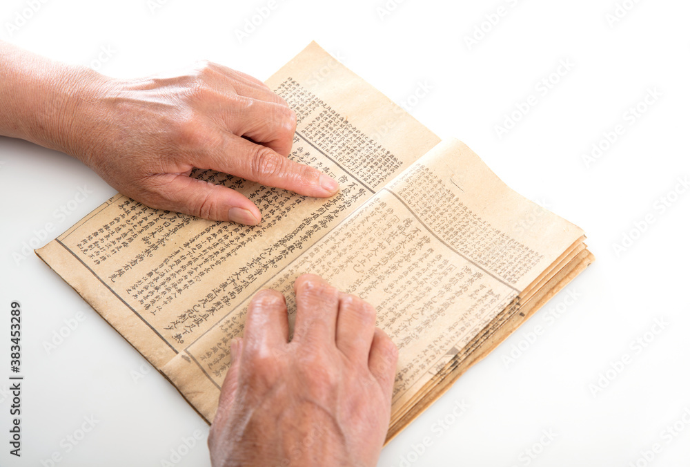 Obraz premium The old man is flipping through an old yellowed book