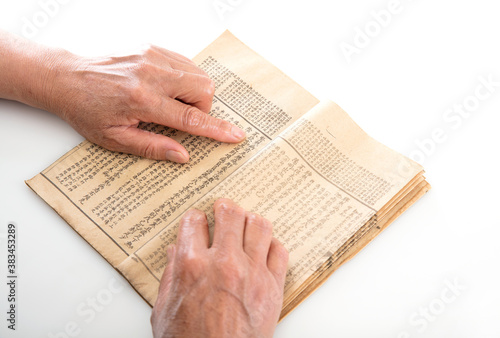 Фотография The old man is flipping through an old yellowed book