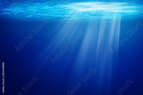 Abstract image of Tropical underwater dark blue deep ocean wide nature background with rays of sunlight.