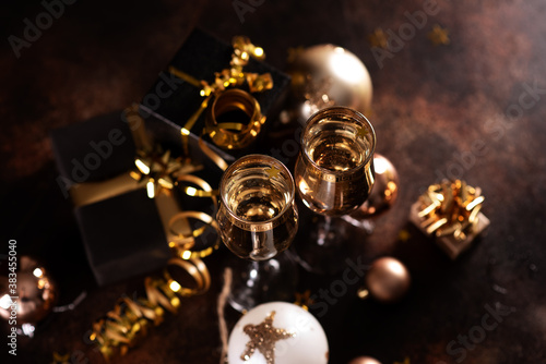 Christmas champagne, gas bubbles, confetti and blurry lights on a dark background