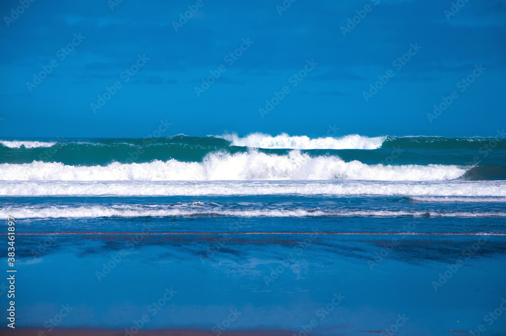 Big powerful ocean waves hitting sandy shore of Ninety Mile Beach, North Island, New Zealand Big powerful ocean waves hitting sandy shore of Ninety Mile Beach, North Island, New Zealand