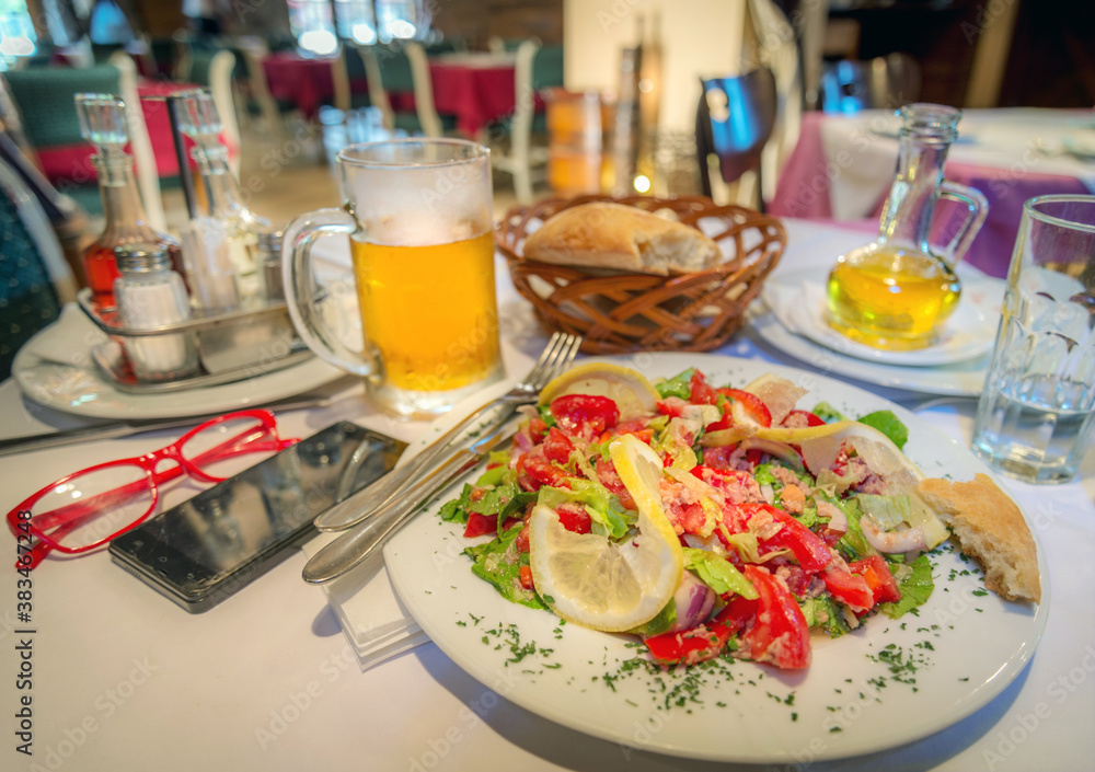 Fresh mixed tomato salad with beer and bread in a basket,Podgorica,Montenegro.