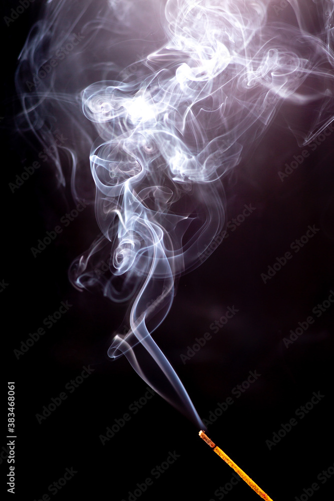 Incense stick with a wisp of smoke. On a dark background Incense stick with a wisp of smoke. On a dark background