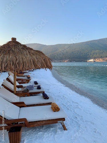 Summer holiday travel background. Idyllic beach. Tropical island luxury resort hotel vacation. Sun umbrella on white sandy beach.