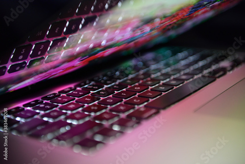 Laptop screen colorful retina display. Reflections from the screen. Flowers reflected. Pink and red colors. Technology theme