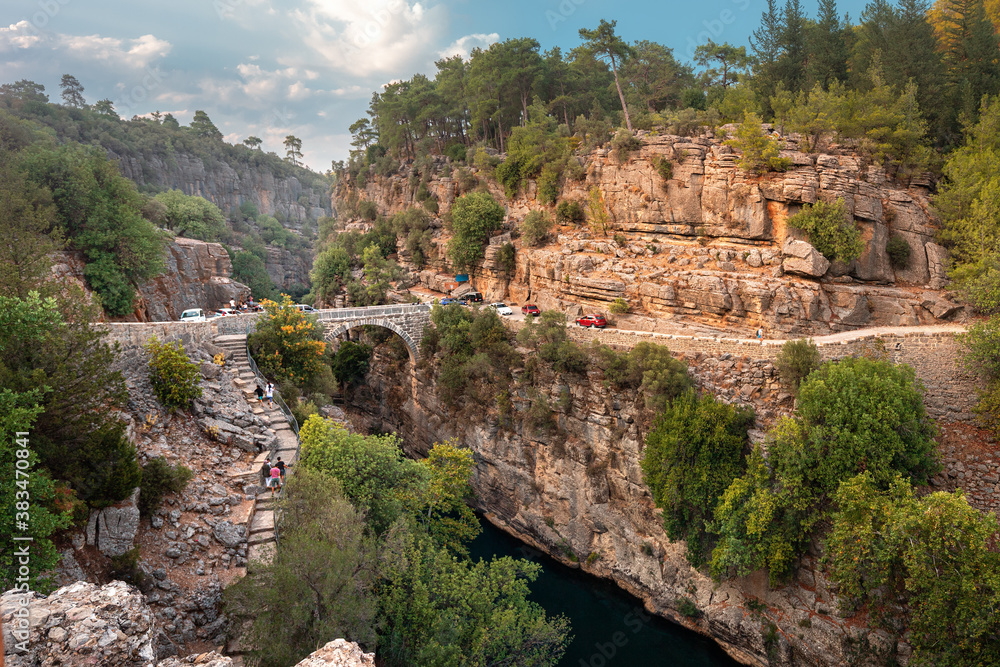 Ancient arch bridge over the Koprucay river gorge in Koprulu national Park in Turkey. Panoramic scenic view of the canyon and blue stormy mountain river