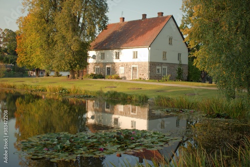 Water lilies on the pond and the reflection of the house in the water