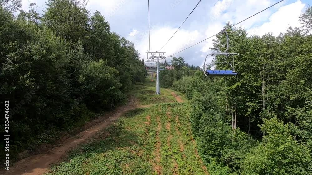 Ropeway movement in forest in mountains on sunny day. Ropeway movement in forest in mountains on sunny day.