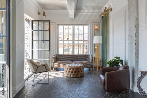 Chic, luxurious guest room design with old-fashioned antique furniture. white walls are decorated with relief. there is a beautiful dark brown parquet on the floor.