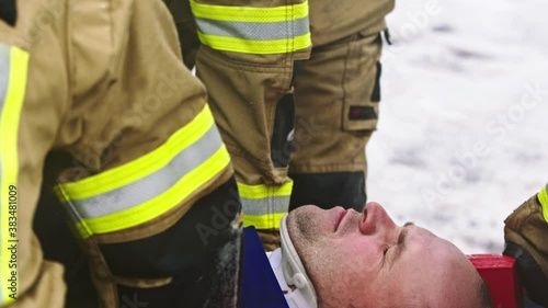 Firefghters lifting injured man. Rescue after car crash accident. High quality 4k footage