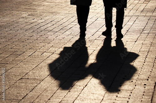 Valokuva Silhouettes and shadows of couple walking down the street