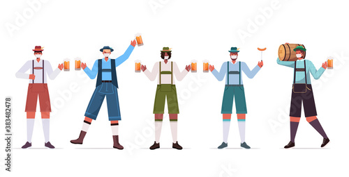 set mix race men in medical masks holding beer mugs Oktoberfest party celebration coronavirus quarantine concept guys in german traditional clothes full length horizontal vector illustration