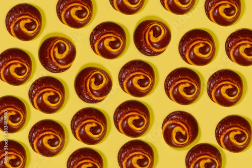 Food pattern. Repeating silhouette of freshly baked buns on a yellow background. Brown round buns on a yellow background. Horizontal