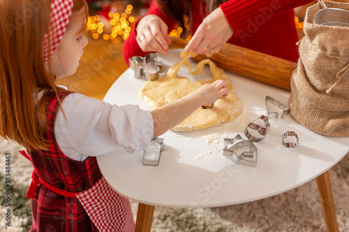 Mother and daughter kneading dough for Christmas cookies