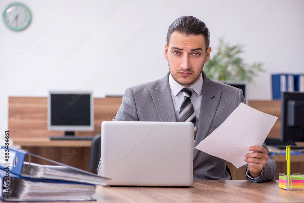 Young male employee working in the office Young male employee working in the office