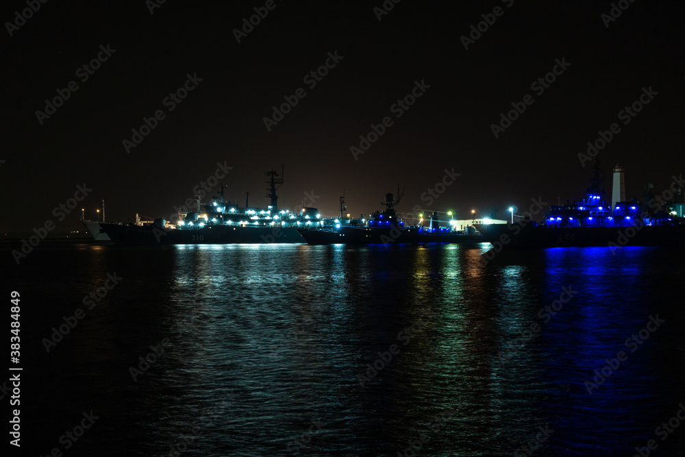 Naklejka premium Night view of warships moored in the middle Harbor of Kronstadt at the wall of Ust-slingshot.