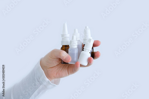 Obraz na płótnie Bottles with nose drops in  hand of a Caucasian woman close up