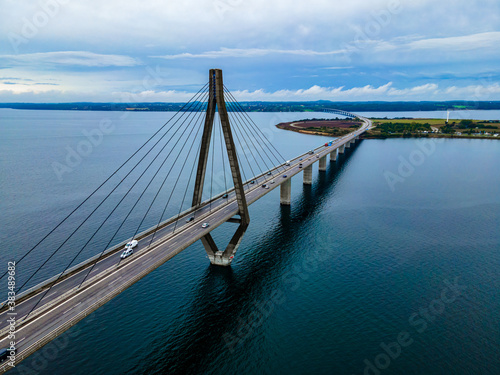 Large suspension highway bridge with cars and trucks passing. Farø bridge aerial view.