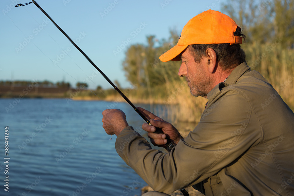 Fishing rod wheel closeup, man fishing with a beautiful sunset. Fishing rod wheel closeup, man fishing with a beautiful sunset.
