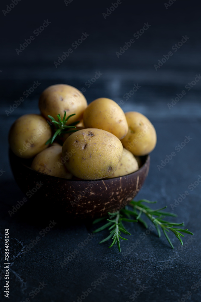 Kartoffeln und Rosmarin in einer Kokosnussschale Kartoffeln und Rosmarin in einer Kokosnussschale